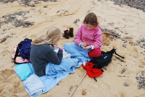 Despite the wind and clouds, the girls set up their towels and sat down for some reading time.