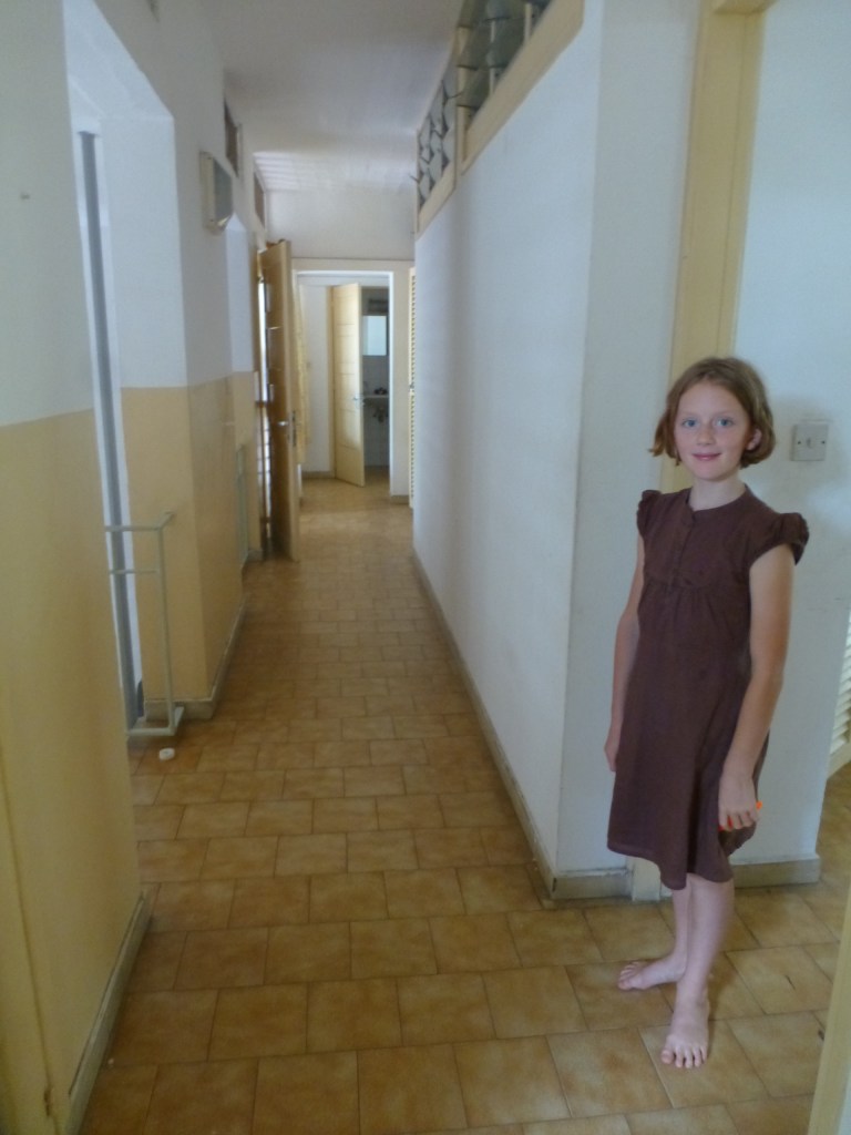Here's a picture of our upstairs hallway and me. At one end is the bathroom and at the other is a storage room. In the middle there are 2 bedrooms - one is ours and the other one is mommy 's and daddy's.